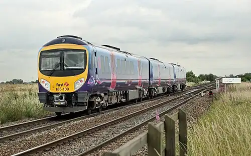 A three-car diesel train passing over a railway junction