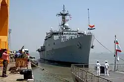 Large, grey ship at dockside