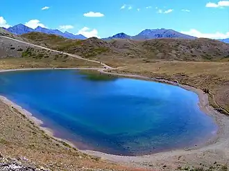 A body of water located within a depression and surrounded by hills.