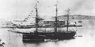 Three-masted warship at anchor in a bay