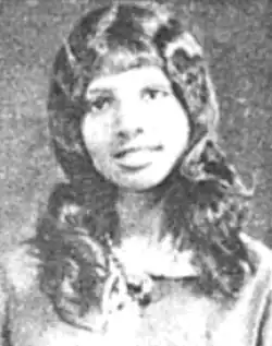 A Black teenaged girl, with long hair and bangs, smiling