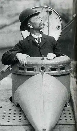 John Holland (1841–1914) stands in the hatch of a submarine