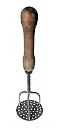 A potato masher with a wooden handle