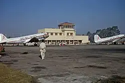Two planes on the tarmac in front of an airport building