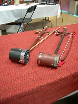Two tro saus with cylinder soundboxes. The instrument on the right has a snakeskin head.