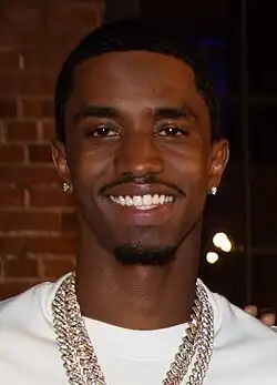 Combs facing a camera and smiling