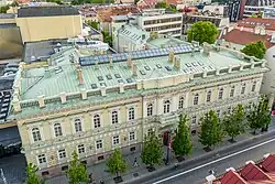 Aerial view of an old, square building with trees in front