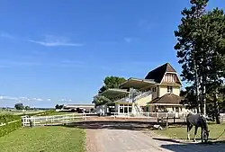 Two buildings for spectators with a road and a horse