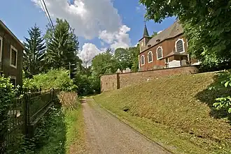 Photograph of a village, with a road in the middle and a church on the right.