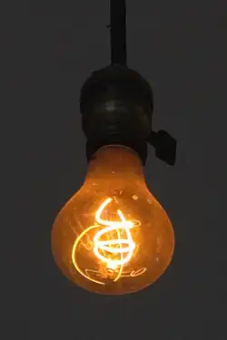 An incandescent light bulb's filament emitting light