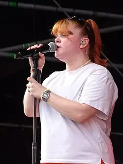 Loi singing into a microphone