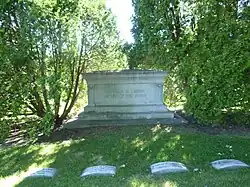 Large monument between two trees, inscribed "Charles M. Loring/Father of the Parks". Loring's grave is center left of four visible.