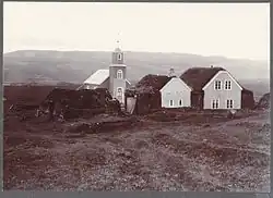 a sepia-toned picture of a farmhouse and small church