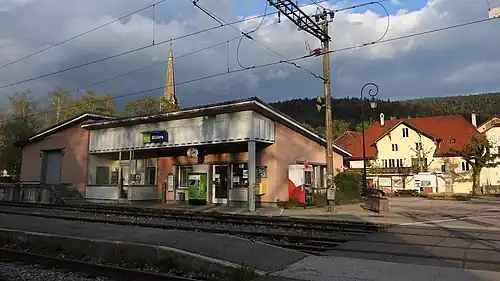 Station building with a ticket machine next to a railway crossing