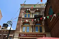 A photograph of the exterior of a building with "Mama Melrose's RISTORANTE ITALIANO where Italy meets California in the heart of the Backlot!" painted on the side