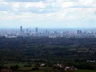View of Manchester from Hartshead Pike, 8 miles (13&nbsp;km) away with Fiddlers Ferry Power Station beyond, 27 miles (43&nbsp;km) away.