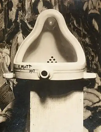 Black-and-white photo of a porcelain urinal signed "R. Mutt"
