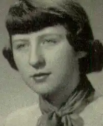 A young white woman with hair cut in straight dark bangs, wearing a neckerchief