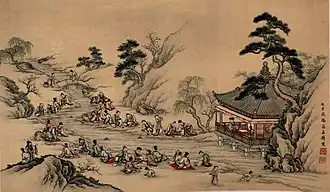 Painting depicting a lively outdoor scene with multiple people gathered on a riverbank, some writing and others conversing, near a pavilion and trees.