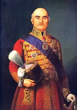 Painted portrait of Miloš Obrenović in a red outfit and blue sash, holding his crown at his side