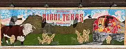 Mural in downtown Miami, TX featuring a windmill, train, and pumpjack, and Hereford cattle.