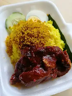 Nasi kuning served with fish and kerisik in Sabah