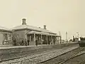 Station building with signal box in background, about 1880