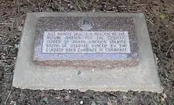 Stone marker with embedded bronze disc; marker reads "This bronze disc is a replica of the actual marker for the geodetic center of North America, located south of Osborne. Placed by the Osborne Area Chamber of Commerce."