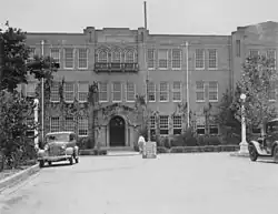 Distant view of a building with a street and cars in the foreground