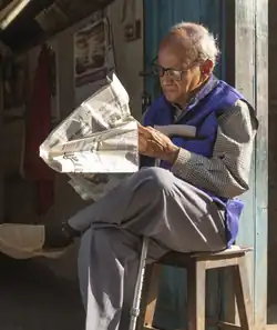 Photo of a man reading a newspaper