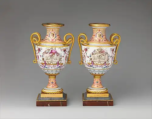 Pair of amphora-shaped vases decorated with festoons, rinceaux, trophies (one made of musical instruments and the other made of scientific ones), and sphinxes