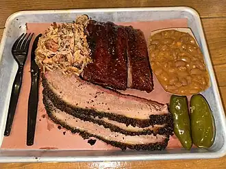 Plate of brisket, BBQ ribs, pulled pork, South Texas beans and pickled jalapeños from the Pinkerton's BBQ San Antonio location