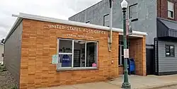 a small one-story brick building with sign reading "United States Post Office, Strum, Wisconsin