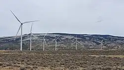 Wind turbines in the foreground with the Pryor Mountains in the background.