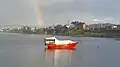 A ketch on Llanquihue Lake, with a rainbow in the background