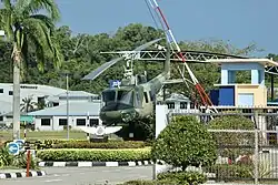 Retired RBAirF / TUDB Bell UH-1 (Bell 205, c/n: 30057, reg.: AMDB 100) helicopter gate guardian displayed inside the main gate of the airbase, September 2023