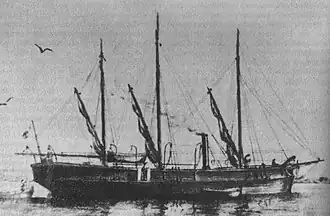 Black and white illustration of a ship at sea with three masts