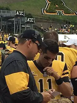 Shawn Clark sharing notes with Appalachian State Quarterback Taylor Lamb on the Sidelines of Kidd Brewer Stadium