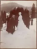 Snowwomen can be as hard to photograph as snowmen. Here, two assistants hold up a blanket behind the sculpture to increase the contrast. Photograph circa 1910