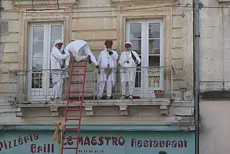 Les Fous climb to Nontronnais' balconies to be served wine.