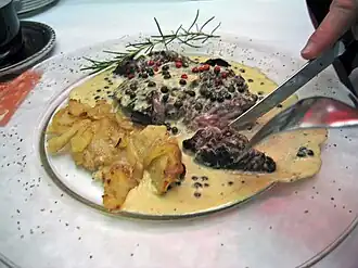 A beef steak served with peppercorn sauce