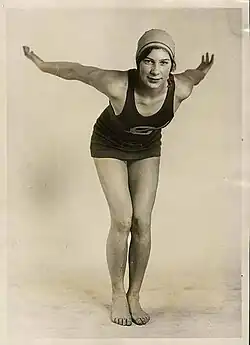 Helene Madison bent over slightly, as if she's about to dive into water. She's wearing a swim suit and swim cap.