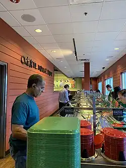 A long buffet line with a man checking out at the end