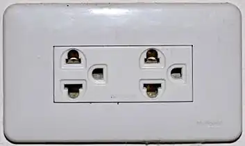 An earthed Thai socket that complies with figure 4 of TIS 166-2549. Although it accepts NEMA plugs, the Thai voltage is 220 V and thus is electrically incompatible with devices designed only for 120 V.