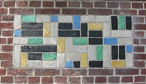 De Stijl – Panel of polychrome bricks on the exterior of the Vakantiehuis De Vonk [nl], a house in Noordwijkerhout, the Netherlands, by Theo van Doesburg, 1917–1919[72]