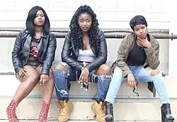 Image 3Three women wearing grunge and streetwear inspired outfits with elements such as distressed jeans, combat boots, tied flannel, and bold lipstick, 2015. (from 2010s in fashion)