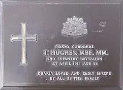 a photograph of a metal plaque inscribed with Hughes' service details