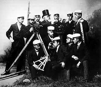 Uniformed group poses with theodolites, level staves and octant.