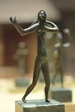 Photograph of a small bronze statuette depicting a dancer, part of the Neuvy-en-Sullias treasure