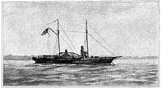 Black and white image of USS Hetzel from a watercolor painting. She lies at anchor, her clipper bow to the right. She carries two masts; a large American flag flies from the gaff of the after (main) mast. The starboard sidewheel is a little aft of directly midship. The single stack is about equally far forward. Superstructure includes a pilot house forward of the stack, some parts of the engines, and a row of cabins aft of the stack. One gun is mounted on the main deck forward, and another is at the stern."
